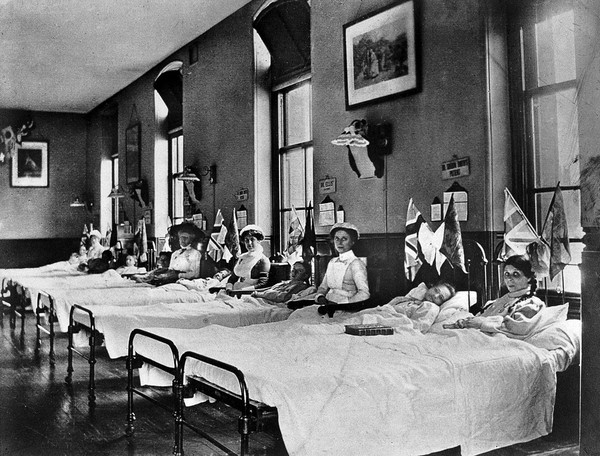 Hahnemann Hospital and Homœopathic Dispensaries, Liverpool: a women's ward, decorated with flags possibly for the coronation of King George V. Photograph.