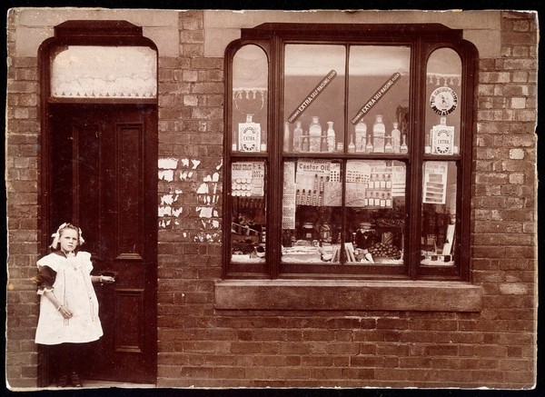 A grocer's shop in England: doorway and shop window. Photograph.