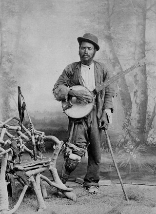 A black banjo player with a wooden leg. Photograph, ca. 1865 (?).