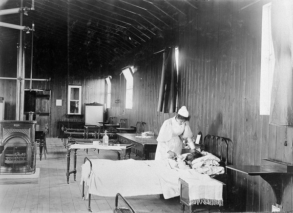 A nurse and a smallpox patient in an isolation hospital, possibly at Ilford, Essex. Three photographs.