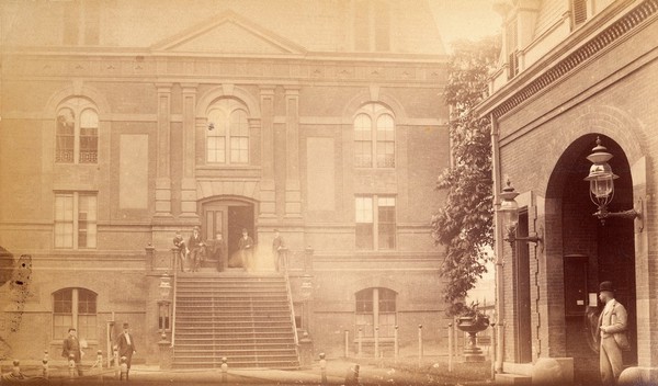 Bellevue Hospital, New York City: a courtyard with (right) back of entrance gateway, (left) a building with pilasters and steep entrance steps. Photograph.