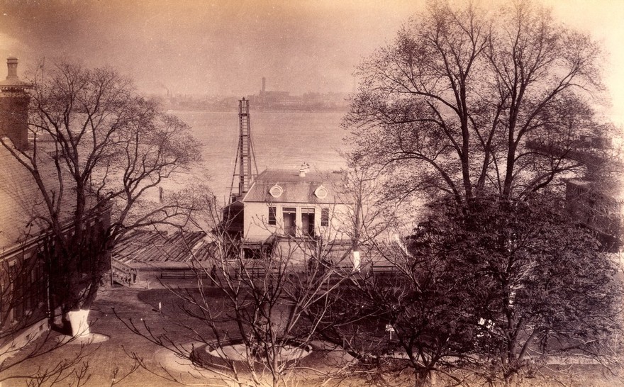 Bellevue Hospital, New York City: a lodge with oeil-de-boeuf windows seen from above next to wharf. Photograph.