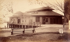 view Bellevue Hospital, New York City: a lodge on a pier over the river, with two men. Photograph.