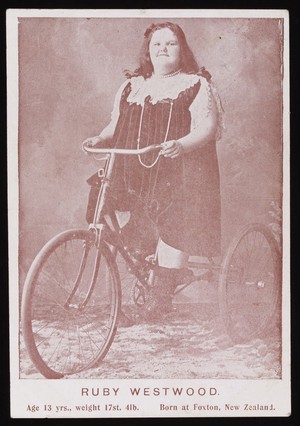 view Ruby Westwood Age 13 years., weight 17st. 3lb, Born at Foxton, New Zealand, riding a large three wheeled bicycle