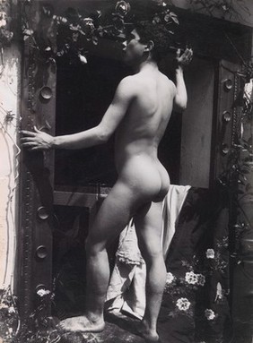 A Sicilian boy, posing naked outdoors, by a doorway. Photograph, ca.1900, by G. Plüschow.