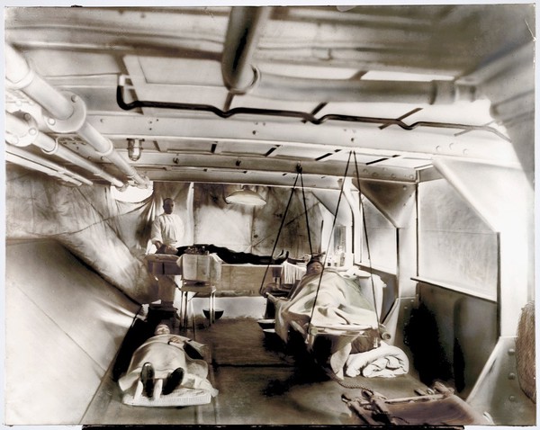 Wounded patients lying on stretchers at a dressing station on board H.M.S. Erebus, Monitor, Russia. Glass negative, ca. 1919.