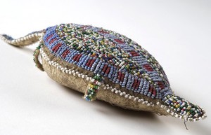 view Sioux Indian amulet in the form of a turtle, worn by girls to ward off illness. Said to contain the umbilical cord of the wearer. Decorated in beading. Northern Plains