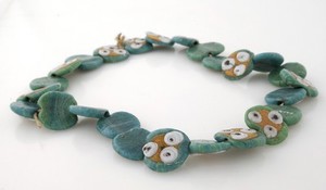 view An amuletic necklace of glass beads. The pattern of onlain circles resembling eyes acts as protection against the evil eye, Hebron, Palestine.