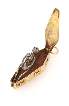 A gold memento mori pendant, used to remind the user of the transience of life and material luxury, containing a decaying corpse inside a coffin. (Open)