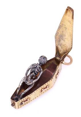 A gold memento mori pendant, used to remind the user of the transience of life and material luxury, containing a decaying corpse inside a coffin. (Open)