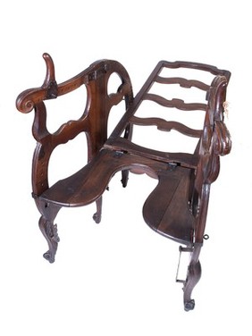 A foldable and adjustable birthing chair, made of walnut wood. European