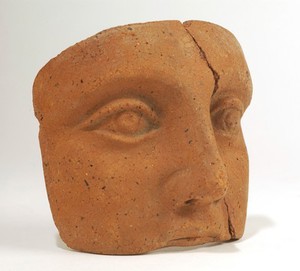 view A clay-backed face. Roman votive offering