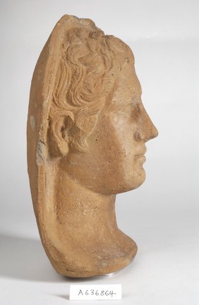 A clay-baked face. Roman votive offering