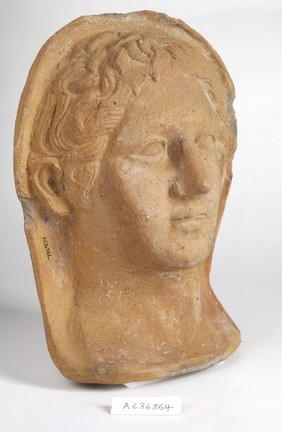 A clay-baked face. Roman votive offering