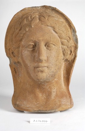 A clay-baked face. Roman votive offering