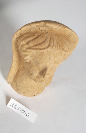 view A clay-baked face. Roman votive offering