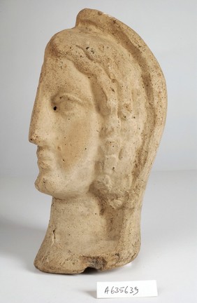 A clay-baked face. Roman votive offering