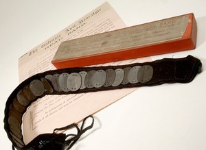 view Galvanic anti-neuralgic headband made up of a series of 24 alternate zinc and copper discs mounted onto a felt and ribbon band. The headband was tied around the head, with the discs resting on the temples, where perspiration would act on the discs by producing a mild galvanic current