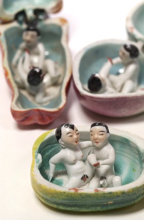 Porcelain fruit containing couple engaged in sexual foreplay