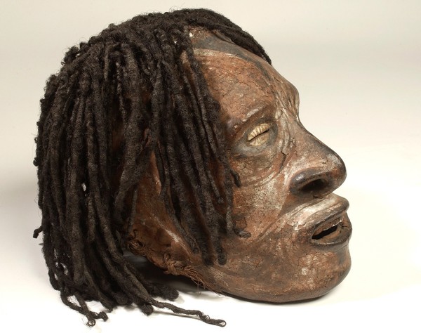Human skull with painted features and cowrie shell eyes. The hair is real. Said to have been used in rituals associated with ancestor worship. Papua New Guinea