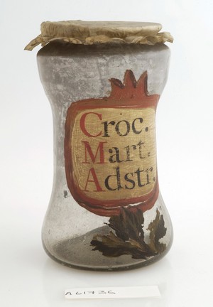 view Apothecary jar for iron oxide with painted label and parchment cover.