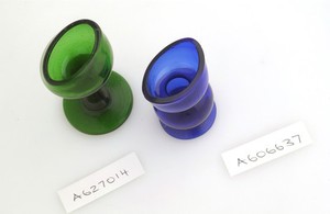 view Two coloured glass eye baths in blue and green.