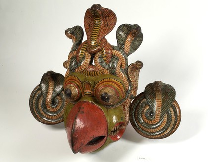 Painted wooden mask, polychrome, with coiled Cobra disc ear-pieces and Cobra headress representing beaked gurulu rassa from Kolam play, Sinhalese