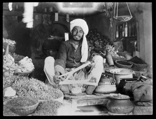 Shopkeeper sitting among his stock