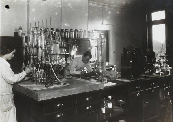 Chemical research lab, Beckenham. Two chemists at work, surrounded by equipment and apparatus.