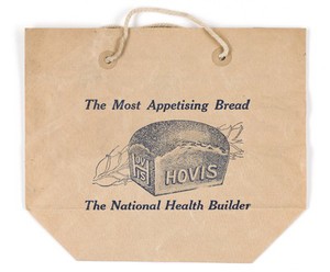 view The most appetising bread : Hovis, the national health builder / [Hovis Ltd.] Brown paper bag with string handles. An illustration of a loaf of Hovis wholemeal bread is printed in dark blue on one side and a slogan in a decorative oval border is on the reverse.