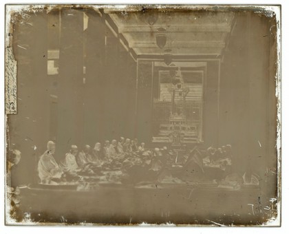 Buddhist monks receiving lunch at Sutthai Sawan Throne Hall, Bangkok. Photograph by John Thomson, 1865.