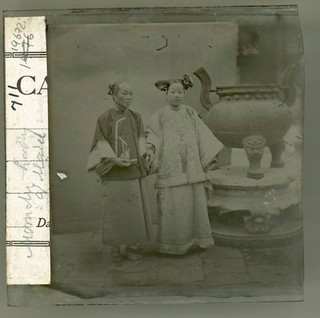 China: a Manchu lady with her maid standing beside a bronze burner, Beijing. Photograph by John Thomson, 1869.