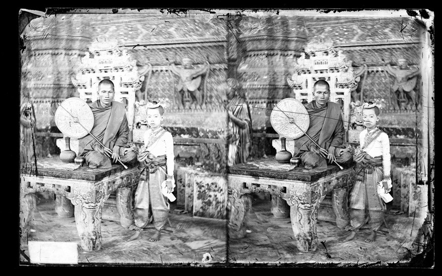 Bangkok, Siam (Thailand): a seated monk and a boy wearing regalia. Photograph by John Thomson, 1865.