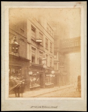 view Villiers Street, Strand: the north-east part, including the shop of William Challice, chemist and druggist; Alsopp's dining and oyster rooms; and a cigar shop. Photograph, 189-.