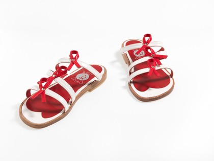 Sandals made of red and white straps incorporating the red ribbon device associated with AIDS. Pair of sandals, 1994.