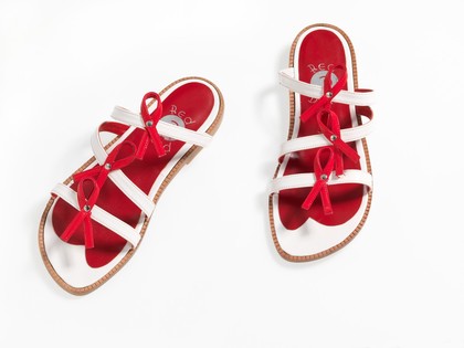 Sandals made of red and white straps incorporating the red ribbon device associated with AIDS. Pair of sandals, 1994.