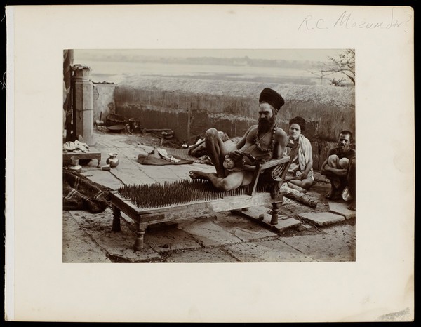 Benares, India: a fakir sitting on a bed of nails. Photograph by R.C. Mazumdar, ca. 1900 (?).