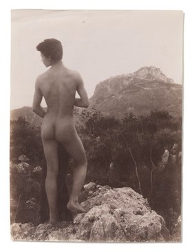 A naked Sicilian male, in a rocky setting outdoors. Photograph, 1900, by W. von Gloeden.