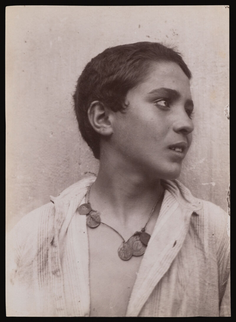 A Sicilian boy, head and shoulders, with a necklace of coins. Photograph by W. von Gloeden, 1900., 1 August 1900, by Wilhelm von Gloeden
