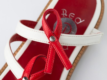 Sandals made of red and white straps incorporating the red ribbon device associated with AIDS. Pair of sandals, 1994.