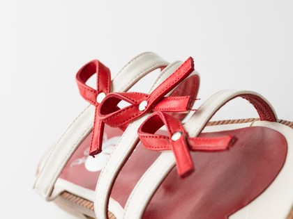 Sandals made of red and white straps incorporating the red ribbon device associated with AIDS. Pair of sandals, 1994.