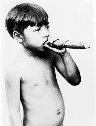 Small native boy of Siam holding a cigar