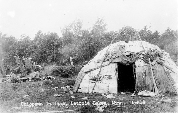 Chippewa Indians camping at Shell Lakes, Detroit Lakes, Minnesota. Showing hut and fire.