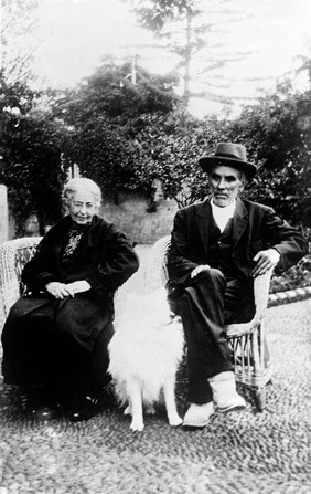 Chippewa Indians camping at Shell Lakes, Detroit Lakes, Minnesota.Old John and Mary seated in a garden with a white dog.