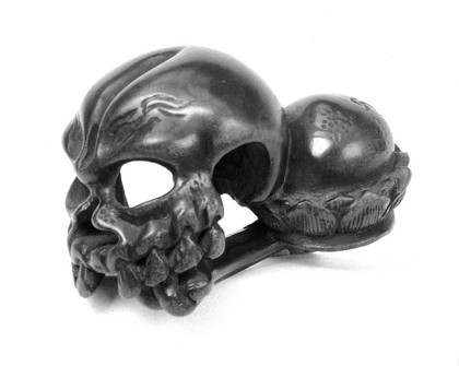 Wood Skull with Tibia and Fibula. They rest alongside the upper part of a Sharito on which is a Bonji Character; emblem of decay. From Doctor Gunther's collection of Netsuke.