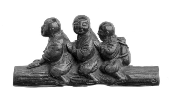 Three wood blindmen astradled on a tree trunk. The hindmost man has a Biwa strapped t his back. From Doctor Gunther's collection of Netsuke.
