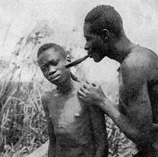 Medicine man cupping youth's cheek