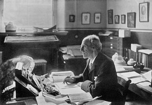 view Karl Pearson, Biometrician, at his desk, 1910