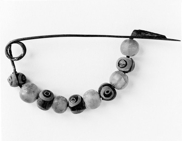 M0013426: Fibula-bow decorated with beads, Iron Age.