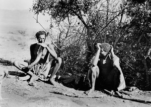 view Swaziland: two young men seated, one of them smoking hemp